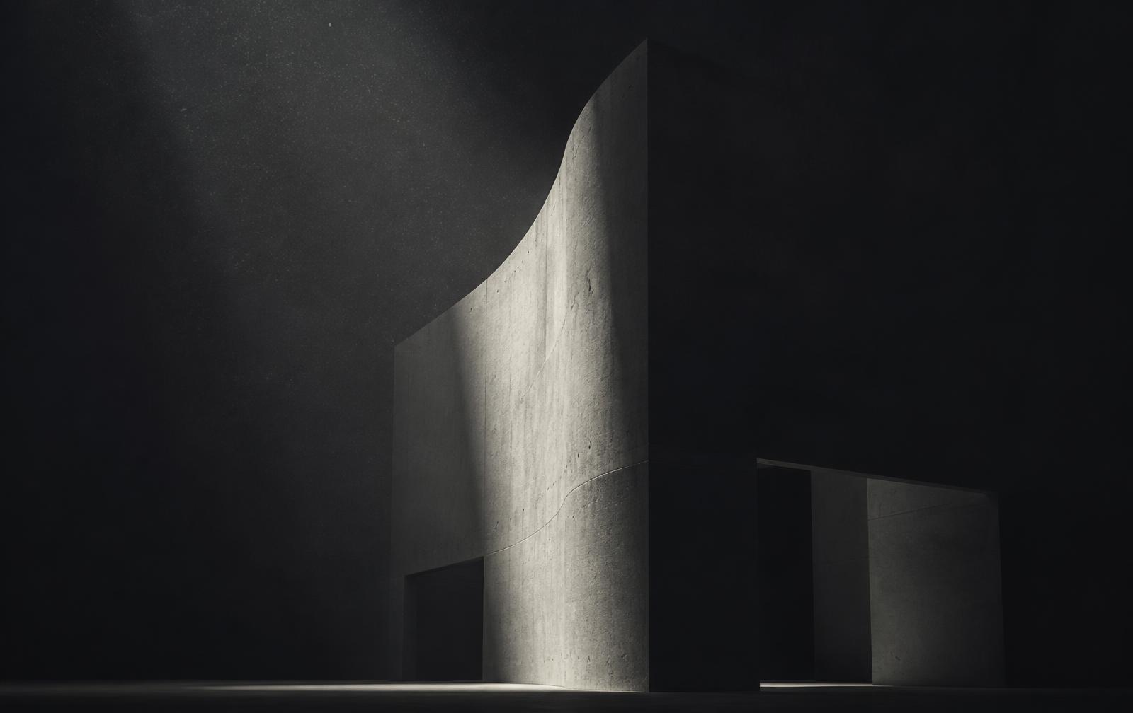 Cinematic concrete form lit by a single beam of light